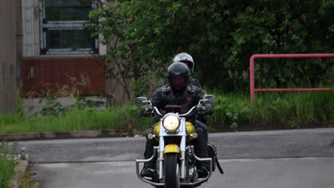 Zwei-Motorradfahrer-Auf-Einem-Goldenen-Chopper-Motorrad-Fahren-In-Einen-Parkplatz