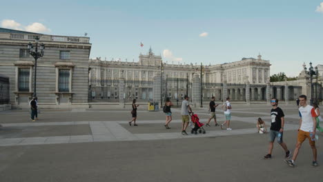 Several-People-Passing-By-The-Royal-Palace-Of-Madrid-During-Daytime-In-Spain