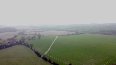 Drones-Volando-Sobre-Campos-En-Medio-De-Una-Ligera-Niebla