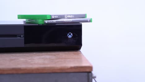 Two-Xbox-One-videogame-on-top-of-a-console,-close-up-pan-right