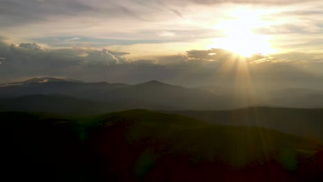 Golden-Sunset-Sun-Rays-in-Beautiful,-Serene-Scene-above-Mountaintops