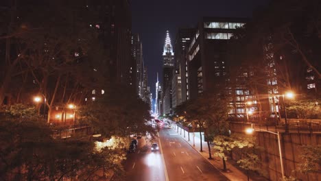 NYC:-Blick-Auf-Die-Tudor-City-Bridge-Bei-Nacht,-Mit-Dem-Chrysler-Building-Und-Den-Wolkenkratzern-Von-Midtown-In-Der-Ferne-Und-Dem-Verkehr-Darunter---New-York-City,-USA