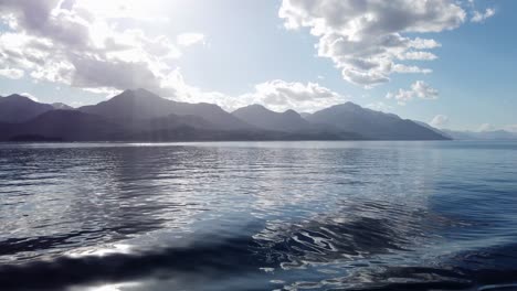 Mountains-of-Patagonia-and-sunbeams-from-smooth-calm-lake-boat-cruise