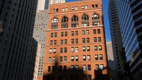 Old-Office-Building-Under-Skyscrapers-of-San-Francisco,-California-USA