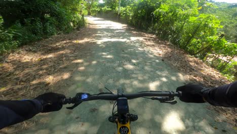 First-person-pov-of-yellow-electric-mountain-bike-racing-on-rural-rough-road