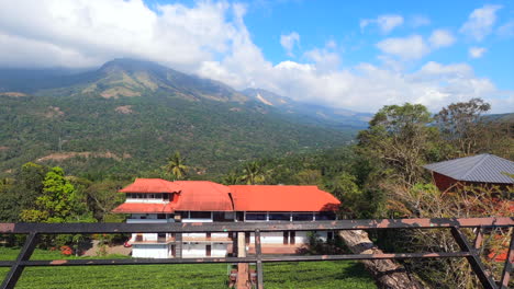 A-wide-4k-beautiful-panning-shot-of-a-beautiful-scenery-with-rain-forest,-lake-and-mountains,-resort-and-tourists-with-a-foggy-climate-taken-from-kerala,-INDIA