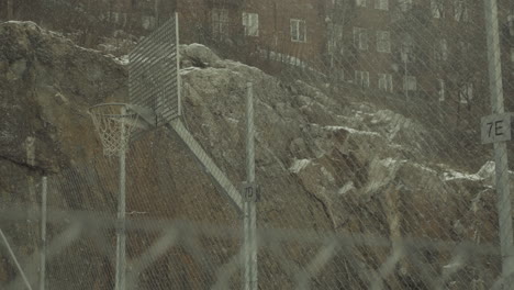 Nieve-Cayendo-Con-Fuerza-Sobre-Una-Cancha-De-Baloncesto-Metálica-Urbana-En-Los-Suburbios