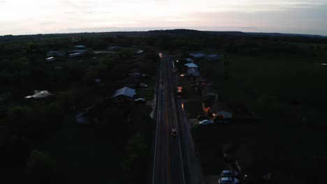 Car-driving-through-town-in-early-morning-or-evening