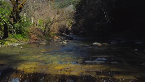 Vista-Aérea-De-Una-Cascada-En-Los-Pirineos-Españoles,-Toma-Cinematográfica-Hacia-Atrás-Cerca-Del-Agua-En-El-Bosque-Oscuro.