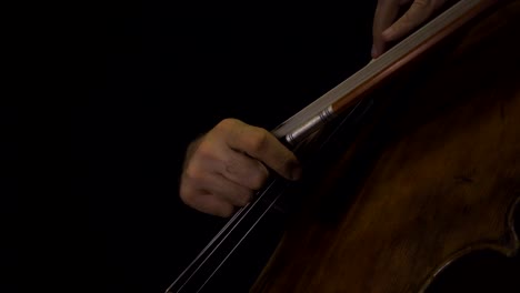 Close-up-of-cellist-playing-pizzicato-notes-with-bow-in-hand