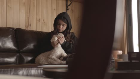 Glückliches-Kleines-Mädchen-Mit-Ihrem-Pudelhund-Sitzt-Auf-Dem-Sofa-Im-Wohnzimmer