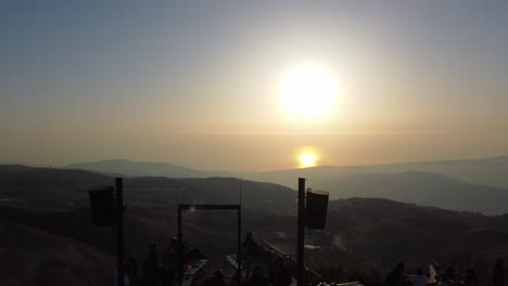 Personas-Cenando-En-El-Bar-De-Cerezas-Congeladas-En-La-Cima-De-La-Montaña-En-Mtein,-Líbano,-Con-Un-Sol-Brillante-De-Fondo