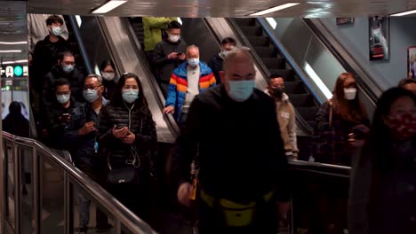 Crowd-of-Asian-Chinese-People-Wearing-Masks-Going-Down-Escalator-During-COVID-and-Coronavirus-in-Hong-Kong