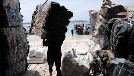 Trabajadores-Cargando-Gran-Cantidad-De-Basura-En-Un-Barco-En-La-Isla-De-Gili-Trawangan,-Indonesia---Reciclaje-De-Basura---Cámara-Lenta