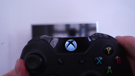 Turning-Xbox-One-videogame-on-with-controller,-close-up