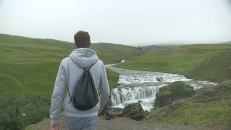 Person-walking-to-a-waterfall