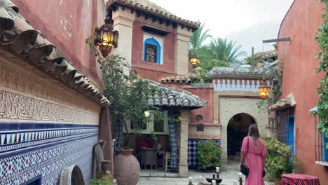 Young-blonde-hair-woman-walking-through-the-typical-full-decored-Arab-courtyard-of-a-mosque-museum