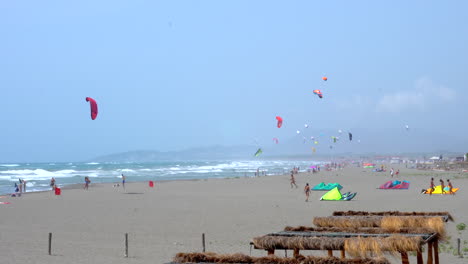 Video-Eines-Windigen-Und-Nebligen-Strandes-Voller-Kiteboarder