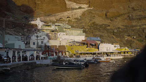 Slow-revealing-shot-of-the-sun-setting-over-busy-restaurants-in-Santorini