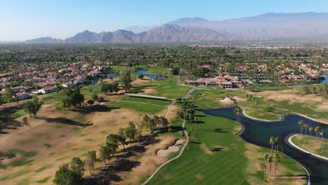 Drone-descends-to-golf-course-in-Palm-Springs-California-USA-with-mountains-in-background