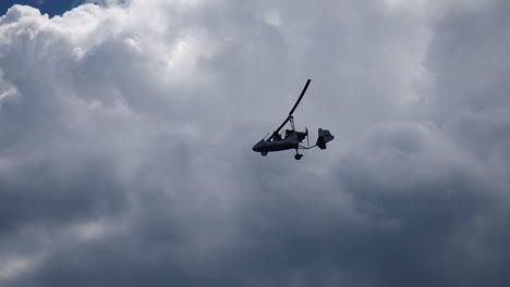 Gyroplane-flying-in-the-sky-over-lake-Attersee,-Austria