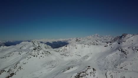 Paisaje-árido-Cubierto-De-Nieve-En-Val-Thorens,-Alpes-Franceses:-Vista-Aérea-Panorámica