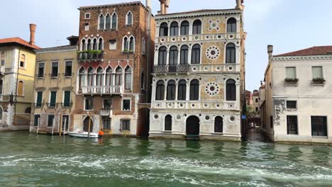 Tourists-on-Private-Motor-Boat-Sailing-In-Venice,-Venetian-Houses-in-Background