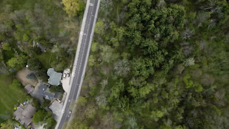 Vuelo-Aéreo-De-Una-Carretera-Con-Vehículos-En-Movimiento-En-Una-Zona-Rural-Con-Casas-En-El-Pueblo-De-Grimsby,-Canadá