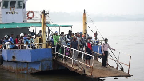 A-Ferryboat-arrived-on-jetty-or-dock-with-full-of-passengers-starting-to-departure-on-platform-video-background-in-pro-res-422-HQ