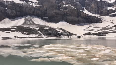 Aerial-View-Above-The-Water-Surface-Of-Gletschersee-At-Klausenpass,-Urner-boden,-Schweiz,-Highlighting-Klausenpass-And-The-Glacial-Lake-Griesslisee