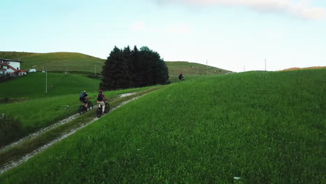 Mountain-bikers-slowly-driving-up-a-steep-hill-in-rural-countryside