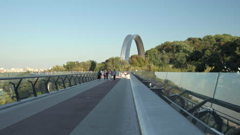 Slider-shot-of-people-walk-across-the-glass-bridge-in-Kiev-on-a-warm-autumn-evening