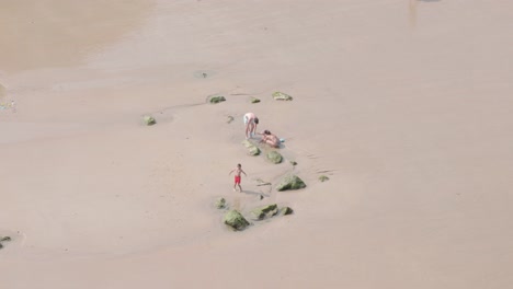 Family-playing-on-some-rocks-on-the-shore-near-the-sea