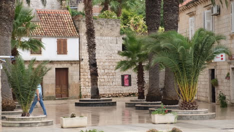 Adult-Man-Walking-At-Town-Square-With-Historic-Buildings-In-Vis-Island,-Croatia