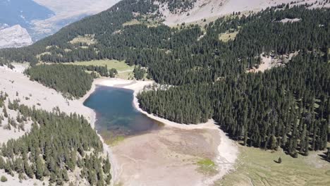 Aerial-horizontal-footage-of-a-lake-in-a-green-natural-environment-with-mountains-in-the-Spanish-Pyrenees