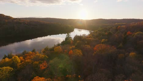 Bosque-De-Muskoka-En-Otoño-Con-Colores-Vibrantes-Y-Un-Lago-Durante-La-Hora-Dorada,-Vista-Aérea