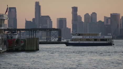 New-York-Waterway-Ferry-Coming-Into-Harbour-Pier-During-Golden-Hour-With-New-York-Skyline-In-The-Background