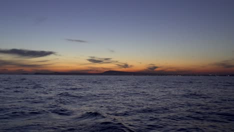 Romantic-sunset-as-seen-from-a-sailboat-in-the-Tyrrhenian-Sea-by-the-Port-of-Naples,-Italy