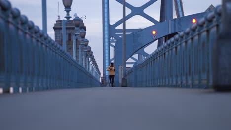 Male-Jogger-Running-Along-Walkway-Of-Benjamin-Franklin-Bridge-Connecting-Philadelphia,-Pennsylvania,-and-Camden,-New-Jersey