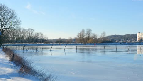 Menschen-Laufen-Bei-Schönem-Sonnigen-Wetter-Auf-Dem-Zugefrorenen-See-Schlittschuh