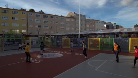 Group-Of-Teenage-Boys-Playing-Soccer-In-Urban-Playground-In-Ordes,-Spain