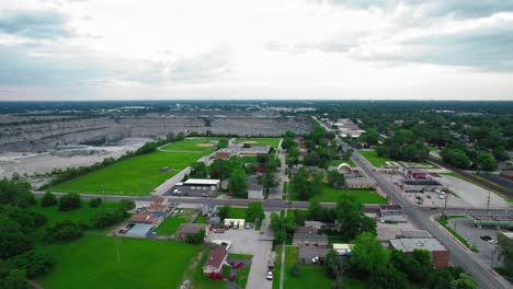 Vista-Aérea-De-Thornton,-Illinois,-Que-Muestra-Una-Pequeña-Ciudad-Con-Una-Gran-Cantera-Al-Fondo-Bajo-Un-Cielo-Nublado