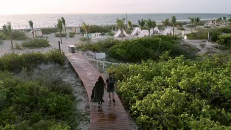 couple-holding-hands-walking-to-beach