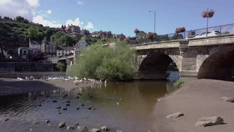 Eine-Drohne-Erhebt-Sich-Langsam-Vom-Ufer-Des-Flusses-Severn-In-Bridnorth-Neben-Der-Brücke-Und-Gibt-Den-Blick-Auf-Die-Oberstadt-Frei,-Shropshire,-Großbritannien-–-30-Sekunden-Version