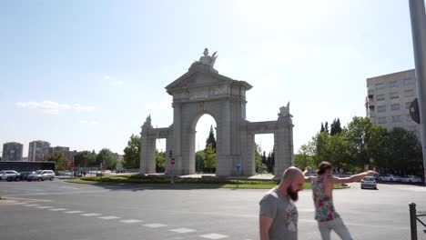 Puerta-De-San-Vicente-Con-Tráfico-De-Coches-Y-Peatones-En-Un-Día-Soleado-En-Madrid,-España