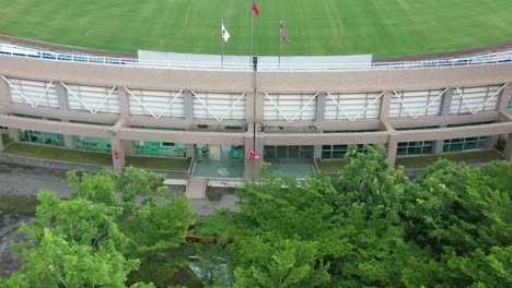 Eine-Filmische-Luftaufnahme-Zeigt-Das-Große-Baseballstadion-Mit-Der-Nationalflagge-Und-Den-Mitarbeitern,-Die-Die-Feldwartung-Durchführen,-Stadt-Douliu,-Landkreis-Yunlin,-Taiwan