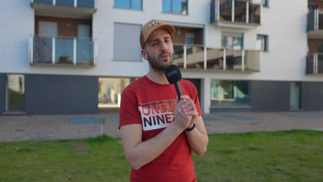 Caucasian-man-in-red-shirt-talks-in-microphone-a-medium-shot