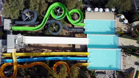 Drone-hovers-in-a-bird's-eye-view-over-a-water-park-with-slides---people-slide-down-the-tube-slides