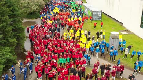 School-kids-on-sports-day-in-colourful-dresses,-Aerial