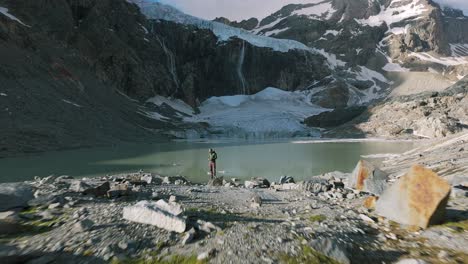 Drone-footage-of-a-lone-hiker-near-the-stunning-Fellaria-Glacier-in-Valmalenco,-Alps